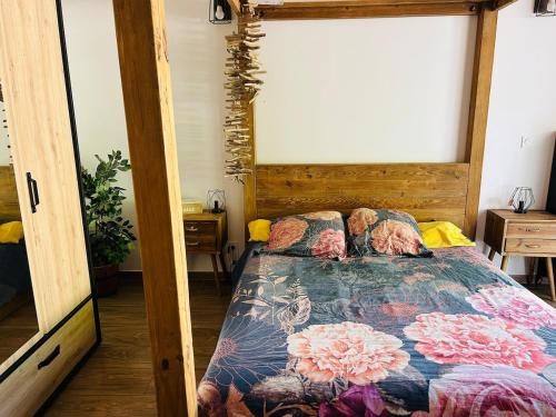 une chambre avec un lit avec une couette fleurie dans l'établissement La maisonnette, à Les Fumades-Les Bains