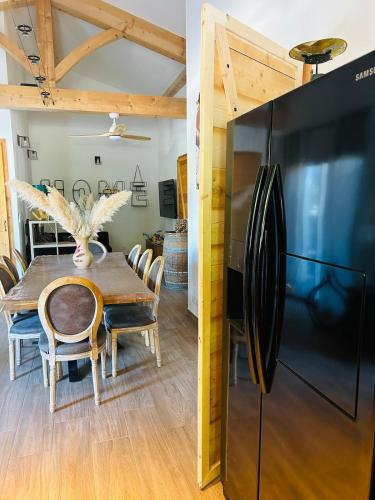 Il comprend une cuisine et une salle à manger avec un réfrigérateur noir. dans l'établissement La maisonnette, à Les Fumades-Les Bains