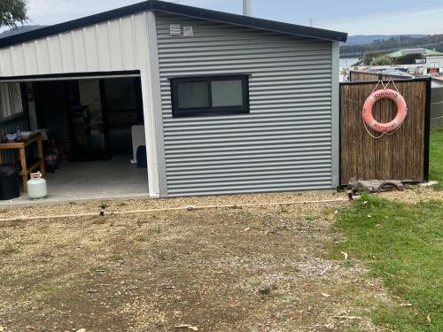 a building with a garage with a rederver on it at studio one bay view in Nubeena