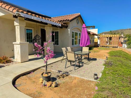 a patio with a table and a pink umbrella at Amethyst Hearth - Family Spa Serenity, Zoo, Beach, Disneyland, Legoland in Vista