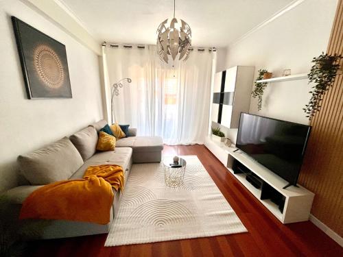 a living room with a couch and a flat screen tv at N3 Apartment in Amadora
