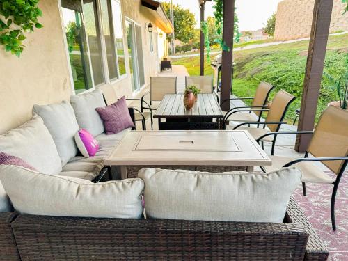 a patio with a couch and a table and chairs at Amethyst Hearth - Family Spa Serenity, Zoo, Beach, Disneyland, Legoland in Vista
