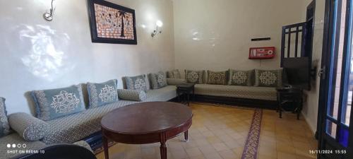 a living room with couches and a table at Duplex 5 familial in Oualidia
