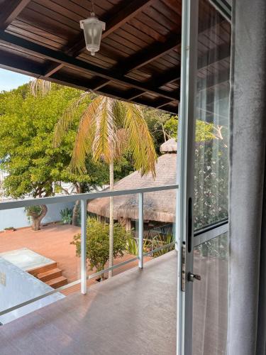 an open door to a balcony with a thatch roof at Essência do Sol Pousada in Florianópolis