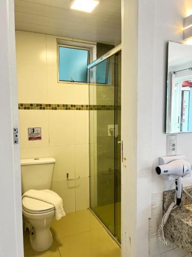 a bathroom with a toilet and a glass shower at Essência do Sol Pousada in Florianópolis