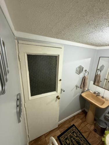a bathroom with a door and a sink at Hostal Rossy in Puerto Montt