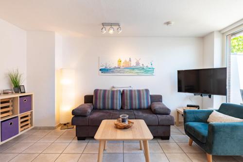 a living room with a couch and a tv at Ankerlicht in Norddeich
