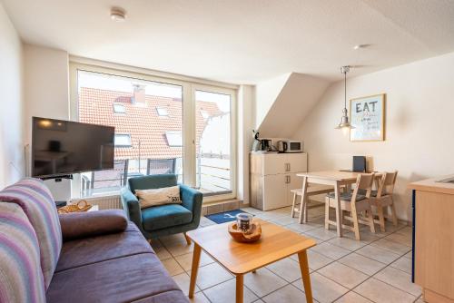 a living room with a couch and a table at Ankerlicht in Norddeich