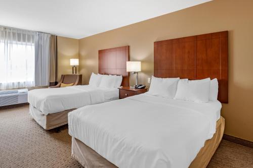 a hotel room with two beds and a chair at Comfort Inn & Suites East Moline near I-80 in East Moline
