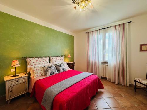 sypialnia z czerwonym łóżkiem i zieloną ścianą w obiekcie Casaserena w mieście San Vincenzo