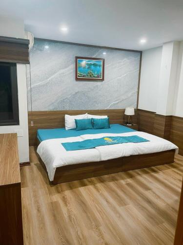 a bedroom with a large bed and a flat screen tv at Aquatic Hotel Cat Ba in Cat Ba