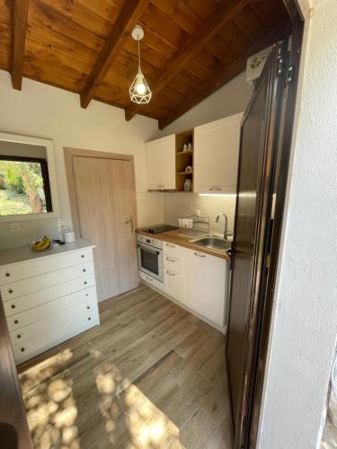 a kitchen with white cabinets and a stainless steel refrigerator at Star Country House in Ormos Panagias