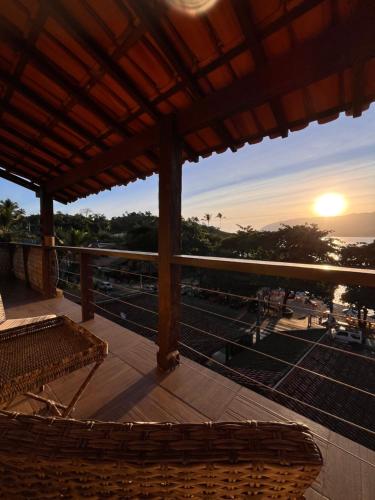 a balcony with a view of the ocean at sunset at Casa amarela in Cambaquara