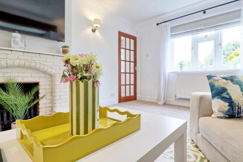 a living room with a vase of flowers on a coffee table at Luxury 4-Bed Family Home in Epping with Parking by LMV Property in Epping