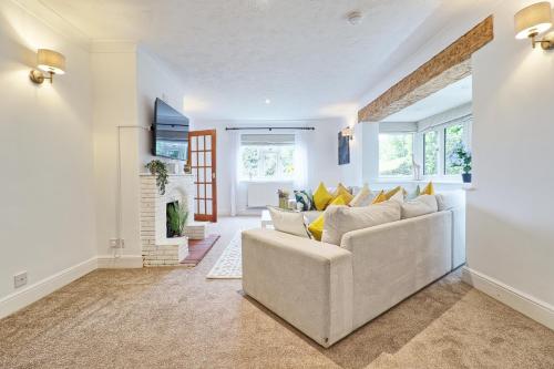 a living room with a white couch and yellow pillows at Luxury 4-Bed Family Home in Epping with Parking by LMV Property in Epping