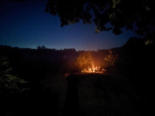 a camp fire in a field at night at Chata w lesie in Zagwiździe