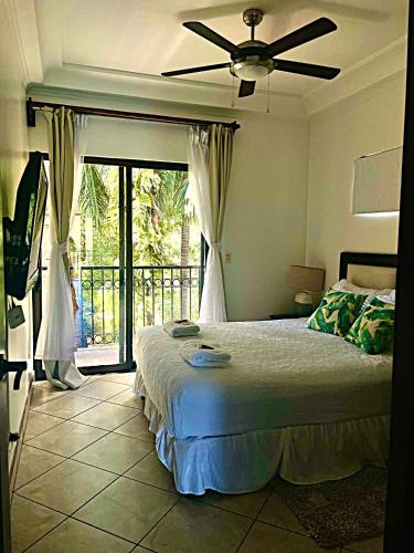 a bedroom with a bed and a ceiling fan at The Oaks Tamarindo Pool Front Condominiums fast wifi in Tamarindo