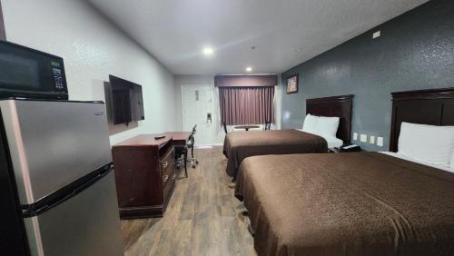 a hotel room with two beds and a desk at Express Inn Hobby Airport in Houston