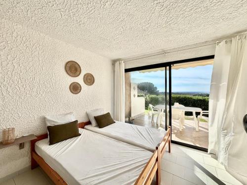 une chambre avec un lit et un balcon avec vue dans l'établissement Appartement Vue Mer en Rez-de-Jardin, à Lumio