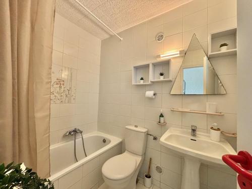 une salle de bain blanche avec des toilettes et un lavabo dans l'établissement Appartement Vue Mer en Rez-de-Jardin, à Lumio