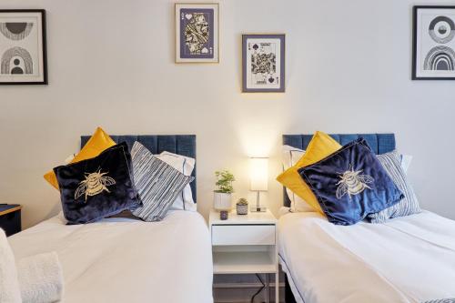 two beds sitting next to each other in a room at Luxury 4-Bed Family Home in Epping with Parking by LMV Property in Epping