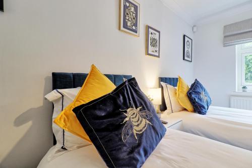 a bedroom with two beds with yellow and blue pillows at Luxury 4-Bed Family Home in Epping with Parking by LMV Property in Epping