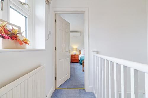 a hallway with a white door and a window at Luxury 4-Bed Family Home in Epping with Parking by LMV Property in Epping