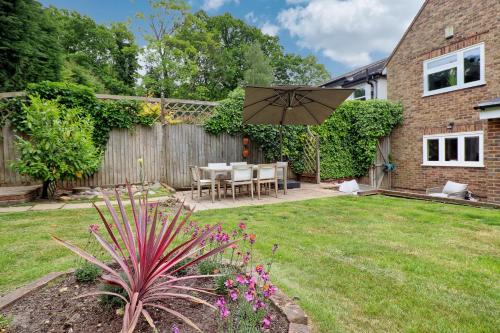 a backyard with a table and an umbrella at Luxury 4-Bed Family Home in Epping with Parking by LMV Property in Epping