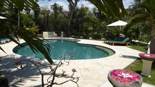 a swimming pool in a yard with a bench at Rumah Kita Villa/hotel in Kalibaru