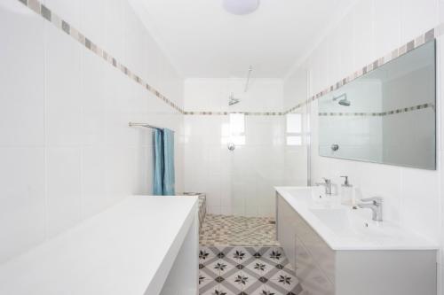a white bathroom with a sink and a mirror at Thalassa in Bettyʼs Bay