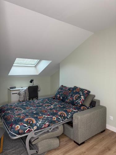 une chambre avec un lit et une lucarne dans l'établissement la Baldi, Limoges, à Limoges