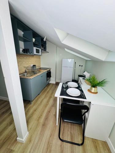 une petite cuisine avec une table et un réfrigérateur dans l'établissement la Baldi, Limoges, à Limoges