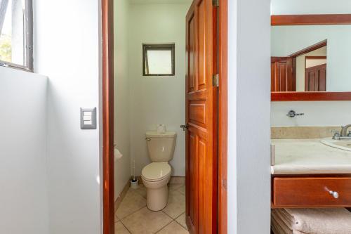a bathroom with a toilet and a sink at The Oaks Tamarindo Pool Front Condominiums fast wifi in Tamarindo
