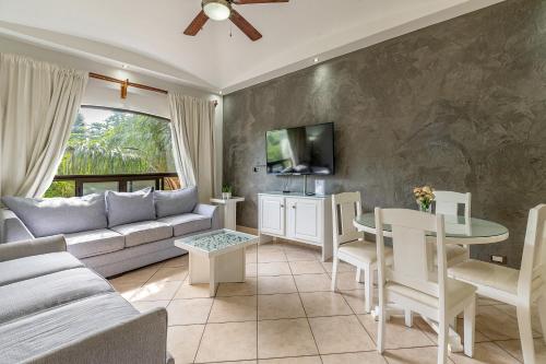 a living room with a couch and a table at The Oaks Tamarindo Pool Front Condominiums fast wifi in Tamarindo