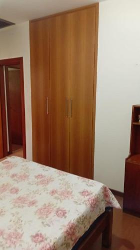 a bedroom with a bed and a wooden cabinet at Castelo da Lagoa in Lagoa Santa