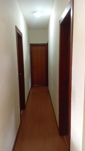 an empty hallway with two doors and a wooden floor at Castelo da Lagoa in Lagoa Santa