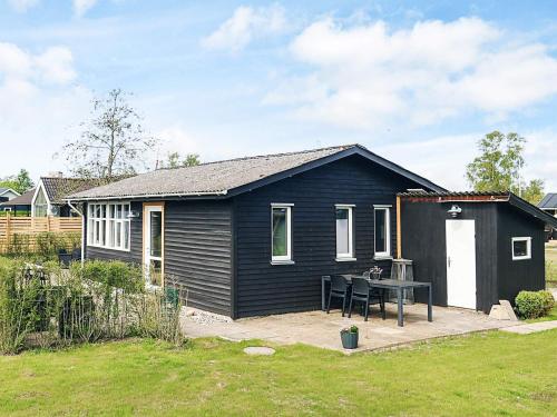a black house with a table in front of it at 7 person holiday home in Hadsund in Hadsund