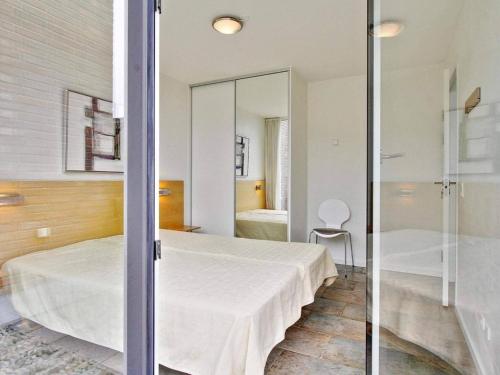 Schlafzimmer mit einem Bett und einer Glastür in der Unterkunft 6 person holiday home on a holiday park in Rømø in Sønderby