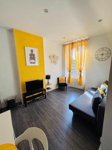 - un salon avec un canapé bleu et un mur jaune dans l'établissement Pétille en champagne - 1 chambre - Terrasse, à Épernay