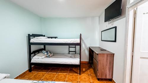 a room with two bunk beds and a table at Hotel Santiago de Tolú in Santiago