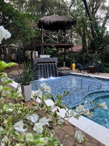 a swimming pool with a waterfall and a gazebo at Los Lapachos in Altos