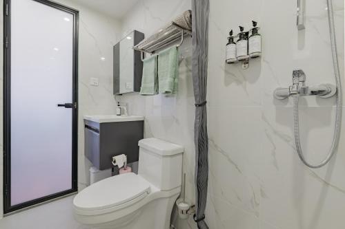 a white bathroom with a toilet and a shower at Hanmer Glamping in Hanmer Springs