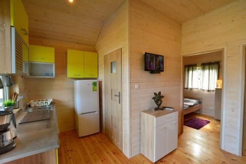 a kitchen with yellow cabinets and a white refrigerator at Ośrodek Wypoczynkowy Lawendowo in Jarosławiec