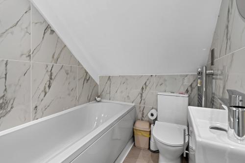 a bathroom with a tub and a toilet and a sink at Archway Haven - 2 min from Station - Free Parking - Courtyard in Swindon