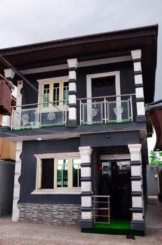 ein schwarzweißes Haus mit einem Balkon in der Unterkunft jobfallodge in Ibadan