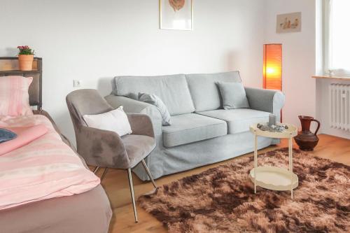 a living room with a couch and a chair at Modern apartment near Bad Nauheim & close to Friedberg in Oberwöllstadt