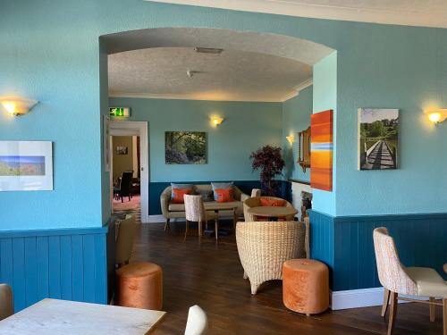 a dining room with blue walls and tables and chairs at Fernhill Hotel in Lyme Regis