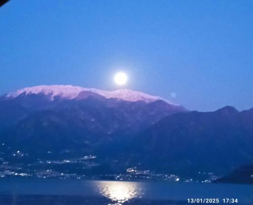 a moon sitting on top of a mountain at Casa Caterina - Riva di Solto - Iseo Lake in Riva di Solto