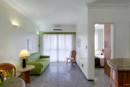 sala de estar con sofá verde y cama en Premium Flats - Saint Martin, en Fortaleza