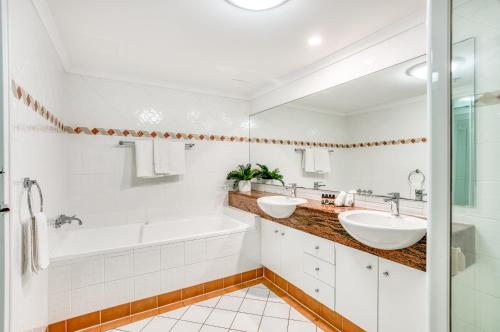 a bathroom with two sinks and a tub and a shower at Xanadu Resort in Gold Coast